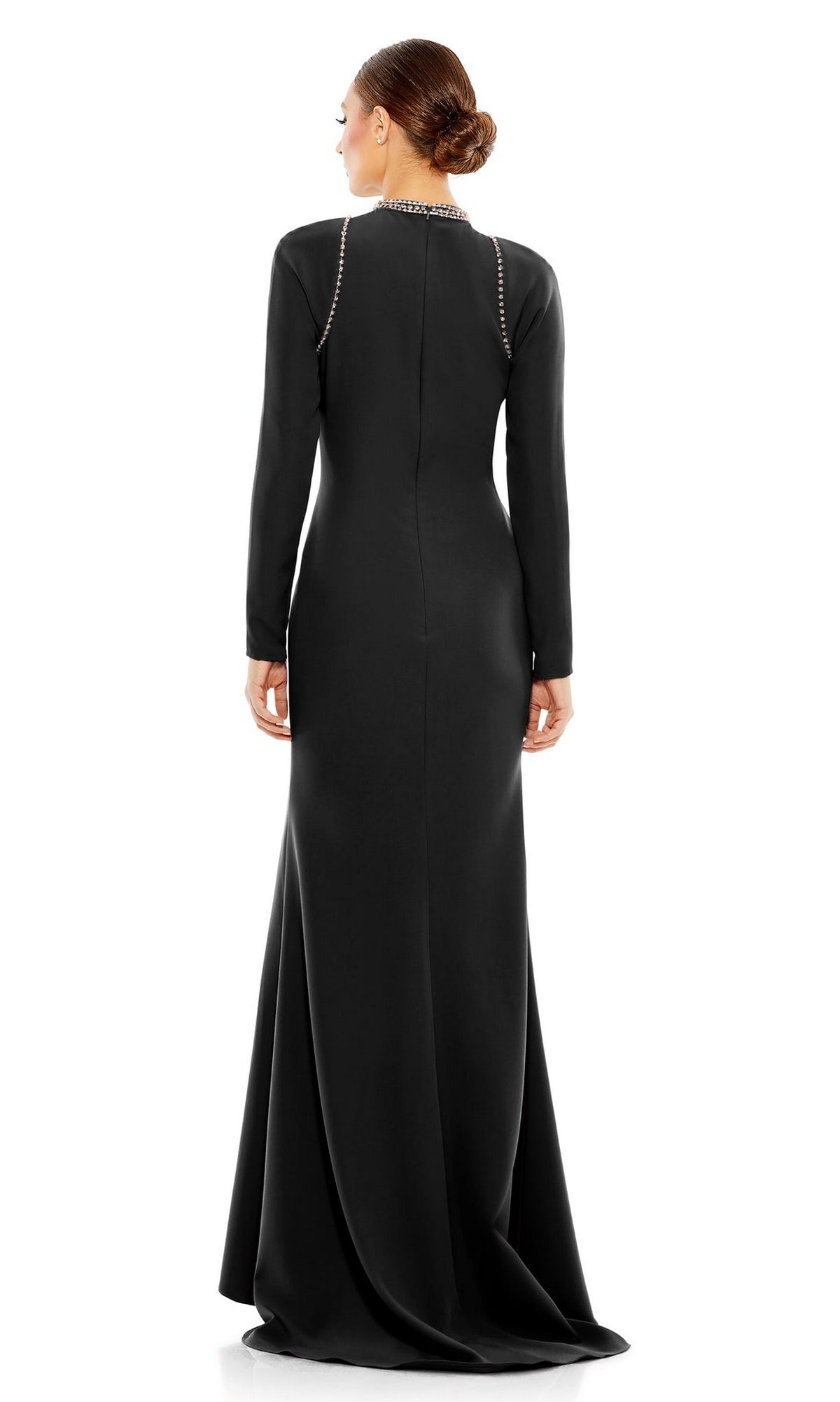 A woman elegantly faces away in the Mac Duggal 26612 long sleeve black formal gown, featuring a fitted silhouette and jeweled neckline.